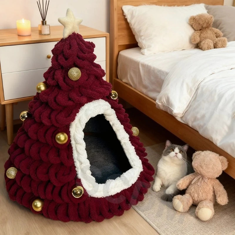 Bordeauxrote Weihnachtsbaum-Kuschelhöhle mit goldfarbenen Kugeln und weißem Eingangsrand neben einem Bett