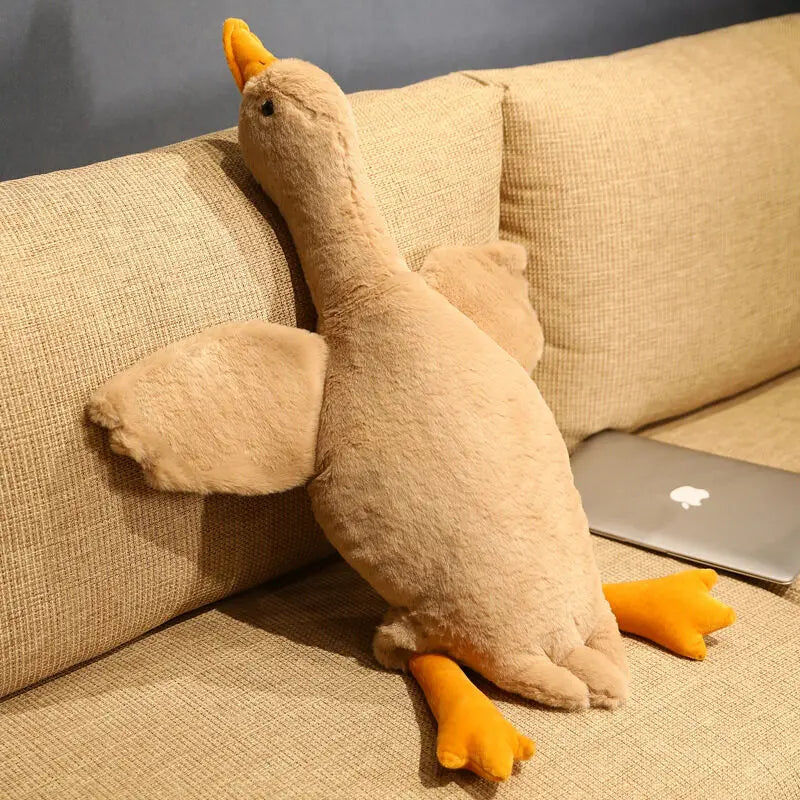 Beige Kuschelente Dottie als ruhiges Hundespielzeug auf dem Sofa