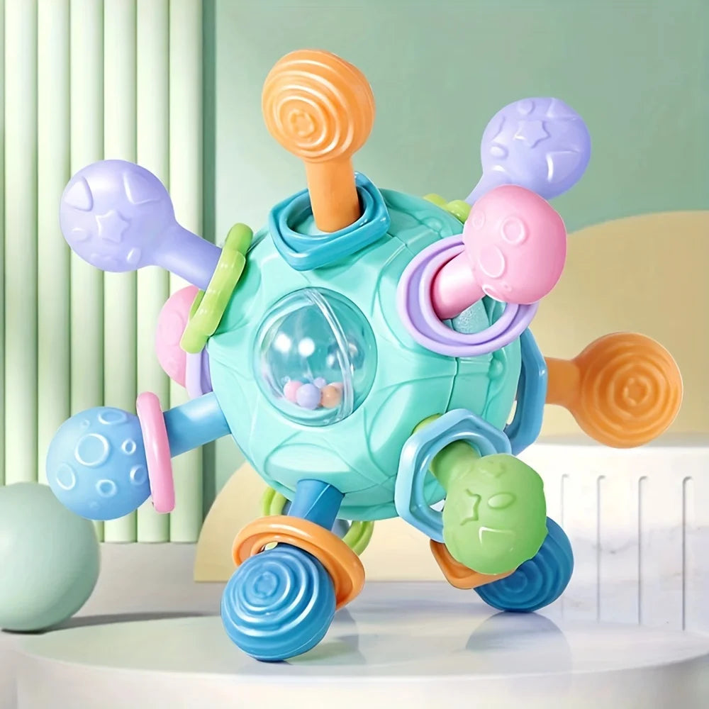 Interaktives Hundespielzeug in Pastelltönen mit strukturierten Noppen und Kugelzentrum auf Tischoberfläche.