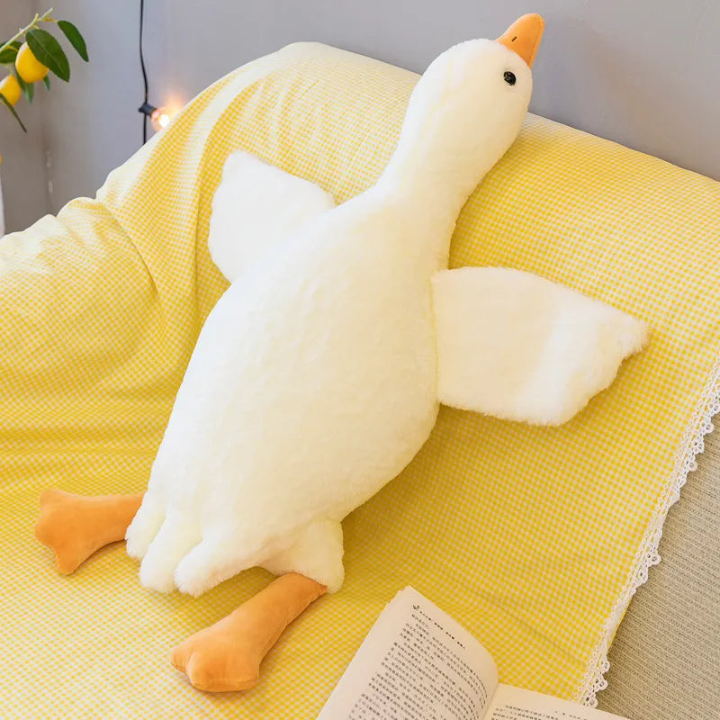 Weiße Dottie Kuschelente auf gelber Decke für ruhige Beschäftigung